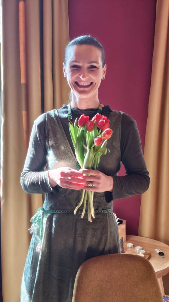 Ștefania-Carmen Rusu zâmbind, cu un buchet de lalele